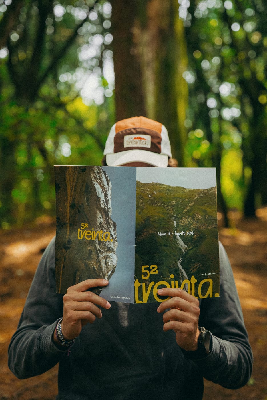 Detrás de la revista abierta, con la gorra asomándose por arriba
